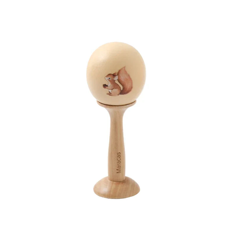 A light wood maraca with a smooth rounded head and brown squirrel design for instruments baby montessori use
