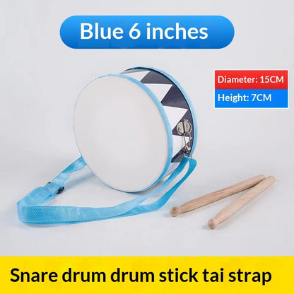Blue wooden children’s snare drum toy set with white head, black and white patterned side, drumsticks, and carry strap