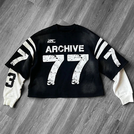 Black cropped sweatshirt with white distressed archive 77 lettering, striped sleeves, and cream contrasting inner layer