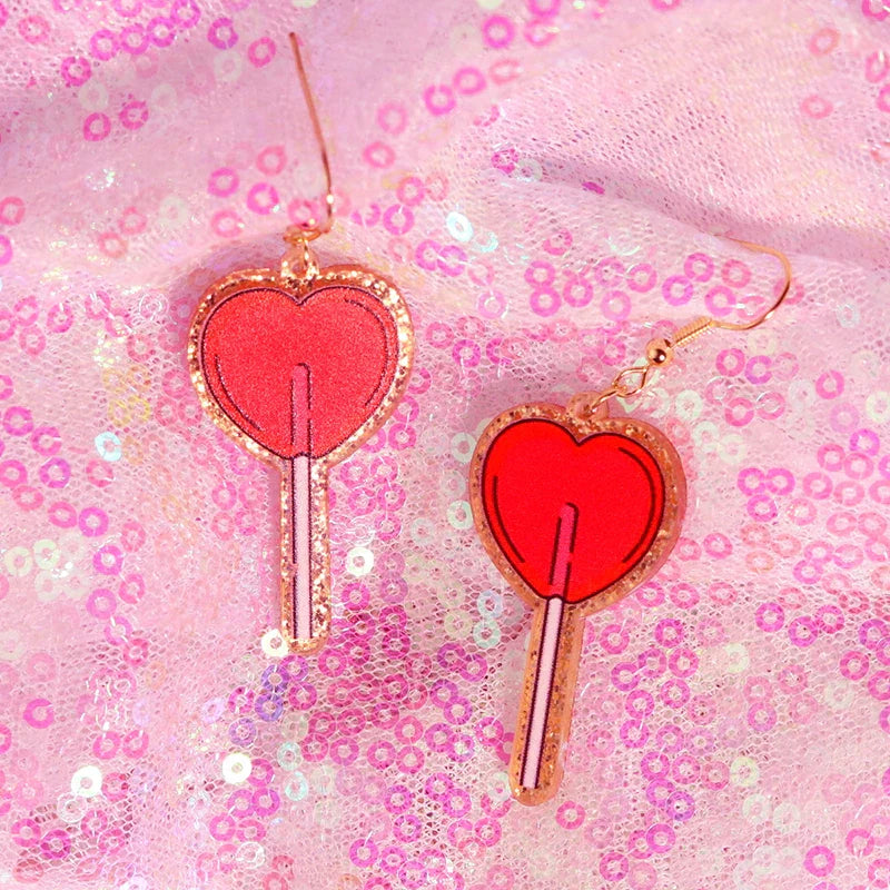 Red heart-shaped y2k earrings with gold glitter edges and pink stick details from cute flame snake lightning queen alien set