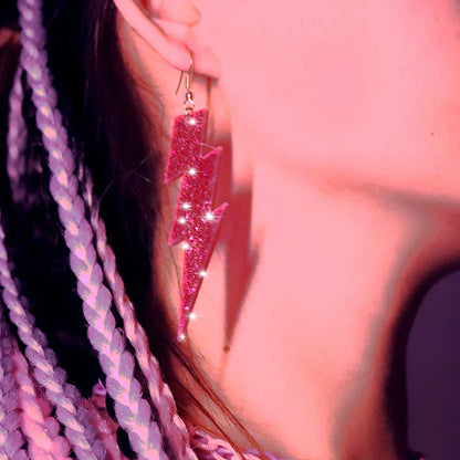 A vibrant pink glitter-covered lightning bolt y2k earring with a metallic hook from the lightning queen alien set