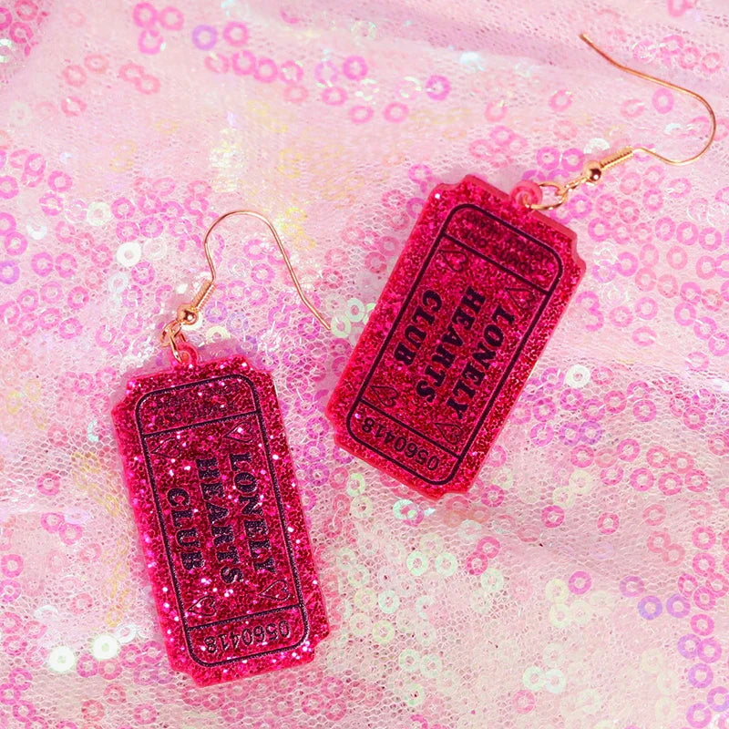 Vibrant pink glittery y2k earrings shaped like tickets with lonely hearts club text for cute flame snake and lightning queen alien style