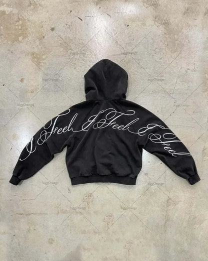 Image of the back of a black oversized zipper sweatshirt with white cursive i feel i feel lettering in y2k harajuku gothic style