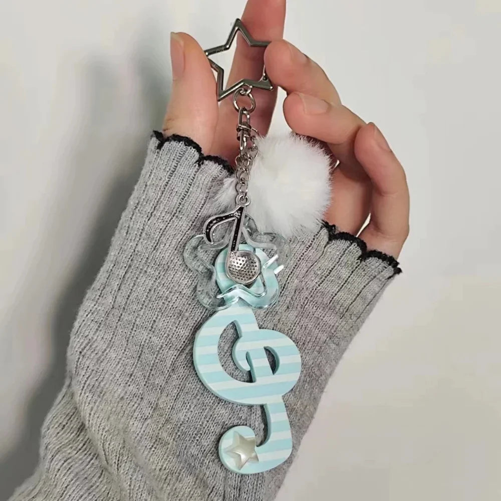 Y2k harajuku musical treble clef keychain in pastel blue and white acrylic with silver star, pom-pom, and mesh detail