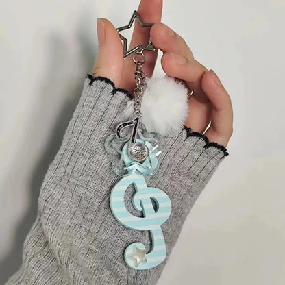 Y2k harajuku musical treble clef keychain in pastel blue and white acrylic with silver star, pom-pom, and mesh detail