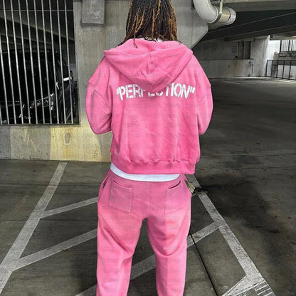 Back view of a pink velour zipper hoodie with white perfection lettering from y2k new streetwear casual set