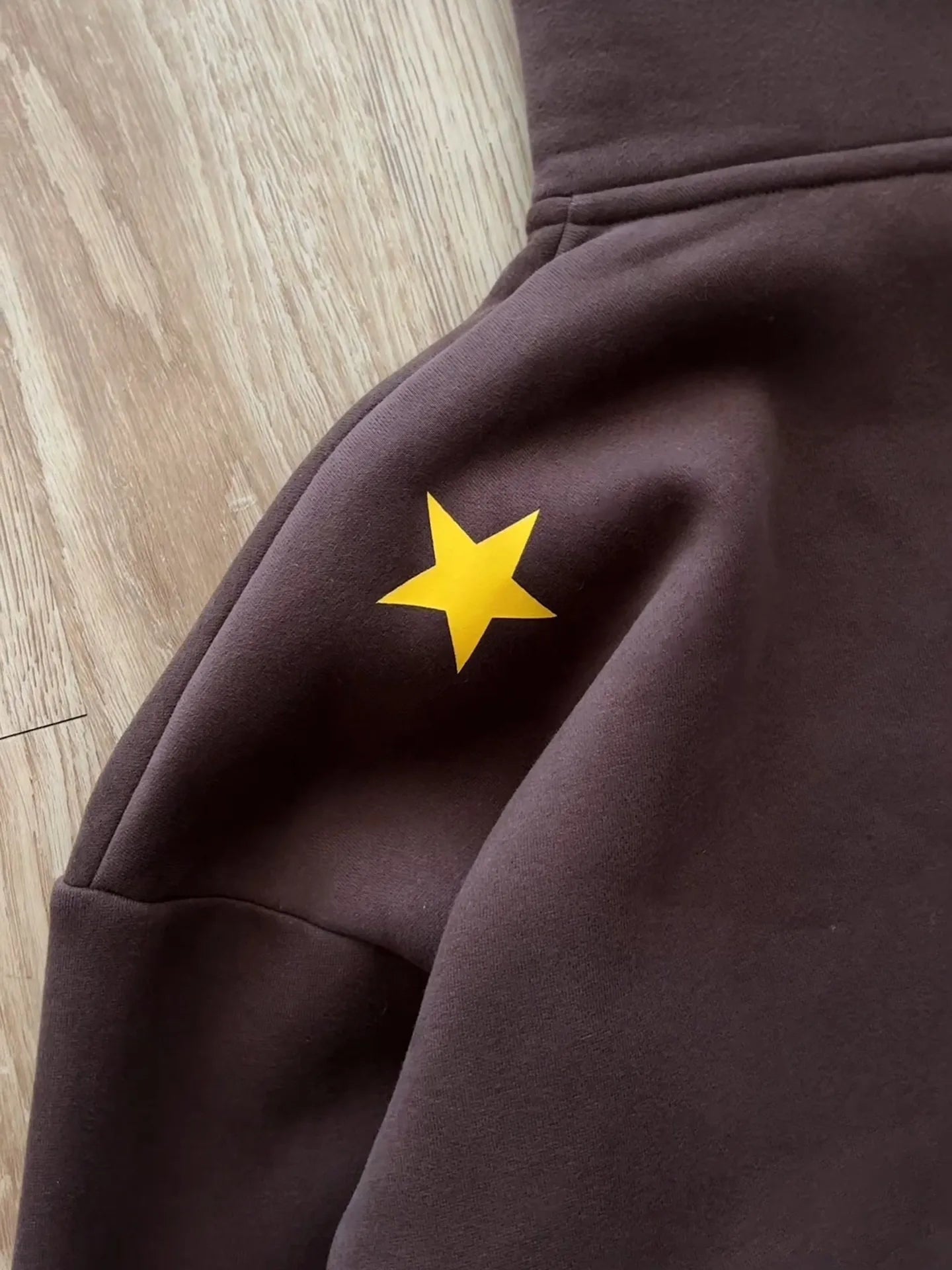 A bright yellow star patch on a dark brown fleece hoodie from y2k stands hiphop japanese jojo hoodies harajuku collection