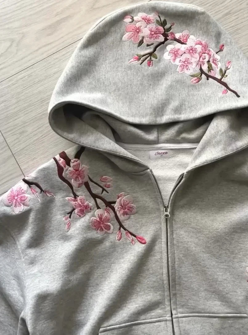 A light gray y2k vintage oversized zip-up hoodie with pink embroidered cherry blossoms on hood and shoulder