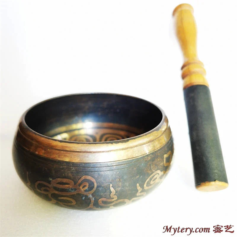 A dark bronze musical instruments tibetan singing bowl five with gold patterns and wooden mallet for yoga healing meditation