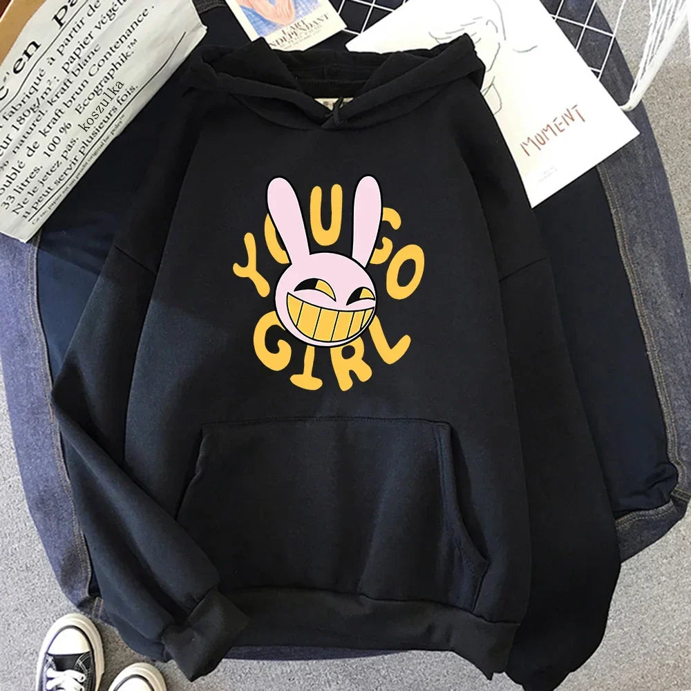 Black hoodie featuring a pink cartoon bunny and yellow you go girl text in a digital circus jax rabbit hoodie unisex style