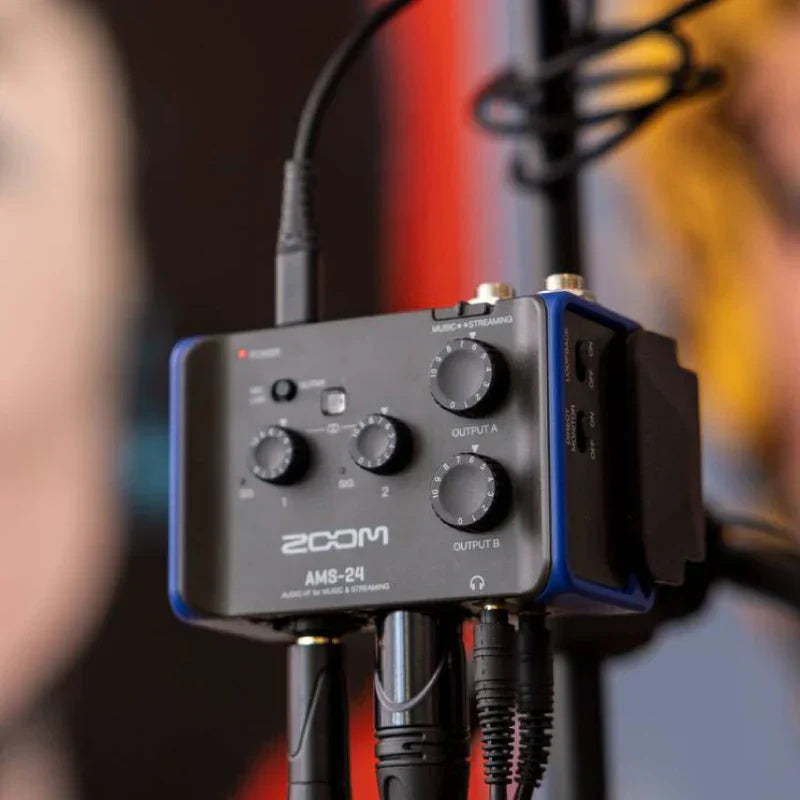 Black and blue zoom ams-24 usb audio interface with multiple knobs and inputs for recording and streaming on pc and mac